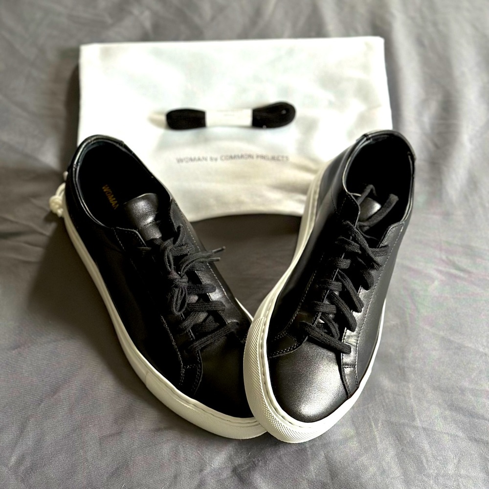 Woman by Common Projects, black leather tennis shoes.